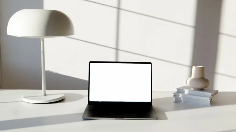 Laptop på ett ljust skrivbord i solljus